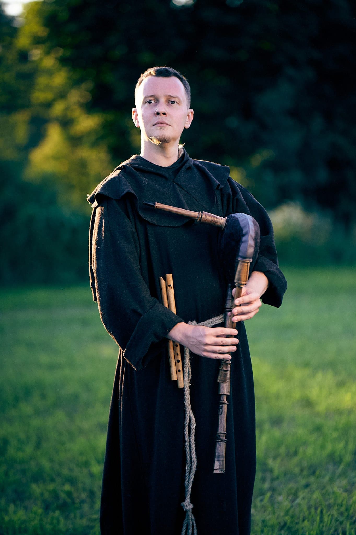 Musician with bagpipes and flutes in a field